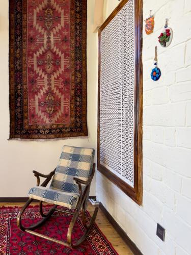 a chair in a room with a rug and a window at Suvenir Hotel in Baku