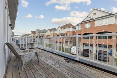 a balcony with a chair on a wooden deck at The Devineridge Executive House in Ajax