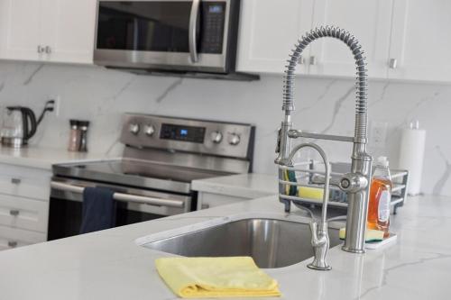 a kitchen counter with a sink and a kitchen with a microwave at The Devineridge Executive House in Ajax