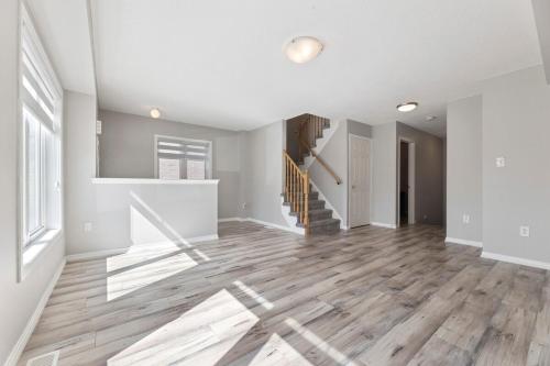 a living room with white walls and wooden floors at The Devineridge Executive House in Ajax