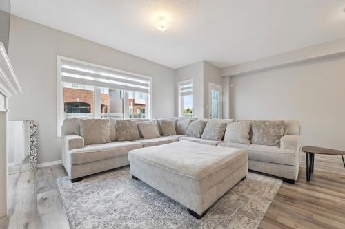 a living room with a large couch and a table at The Devineridge Executive House in Ajax