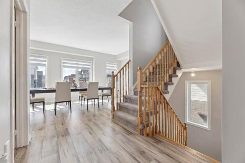 a dining room and kitchen with a dining table and stairs at The Devineridge Executive House in Ajax
