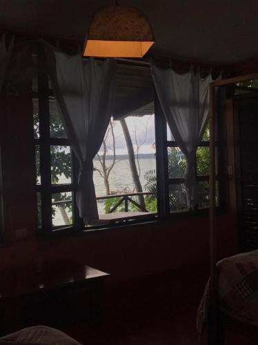 a room with a window with a view of the water at El Encantadero in Jobompiche