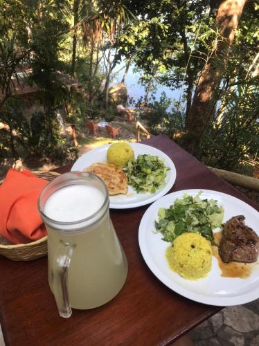 two plates of food on a table with a glass of milk at El Encantadero in Jobompiche