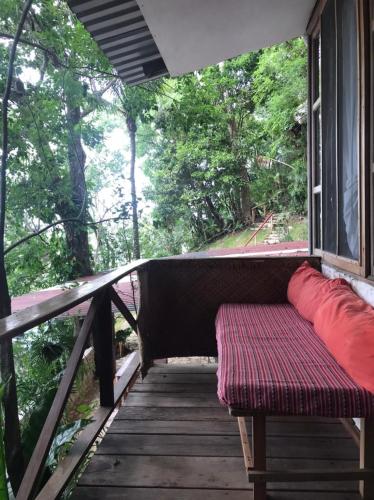 a porch with a bench on a wooden deck at El Encantadero in Jobompiche