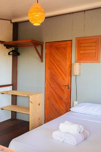 a bedroom with a bed and a wooden door at Casa Maracanã in Barreirinhas