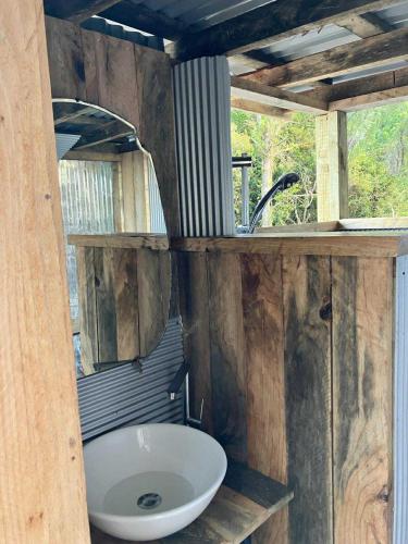 a bathroom with a sink and a mirror at Golden Bay Glamping in Takaka