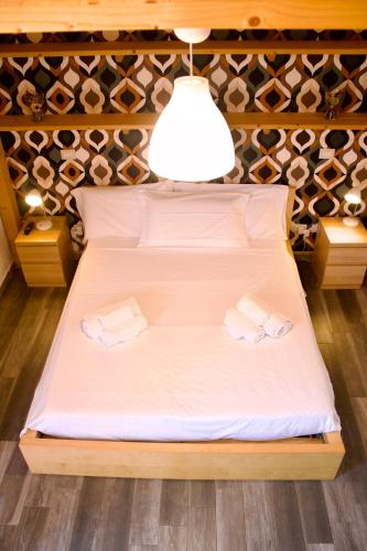a bedroom with a bed with two towels on it at Viola Nel Parco in SantʼAlfio