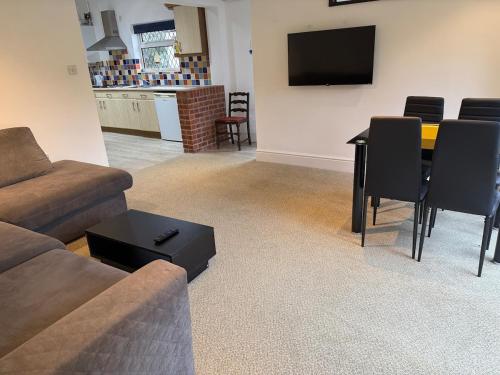 Bright & Cozy Countryside Bungalow في Tollerton: غرفة معيشة بها أريكة وطاولة