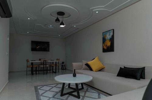 a living room with a couch and a table at Appart Hôtel Golden Sky Home Café Restaurant & Spa in Beni Mellal