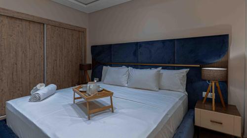 a bedroom with a large bed with a blue headboard at Appart Hôtel Golden Sky Home Café Restaurant & Spa in Beni Mellal
