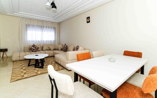 a living room with a white table and chairs at Appart Hôtel Golden Sky Home Café Restaurant & Spa in Beni Mellal
