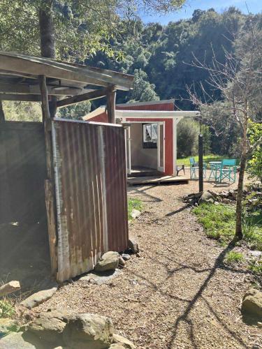 a house with a gate in front of it at Golden Bay Glamping in Takaka