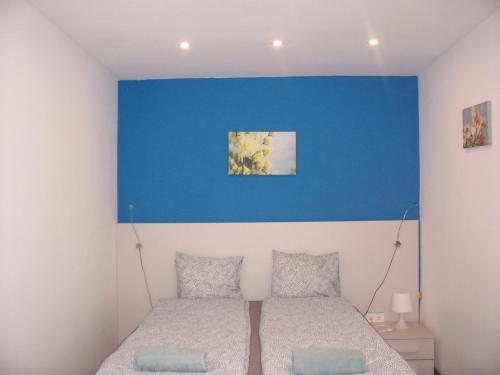 a bedroom with a blue wall and a bed at Harmony Apartment Near Opera in Budapest
