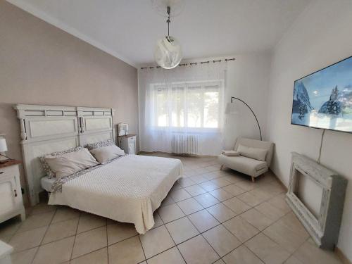 a bedroom with a bed and a chair in it at La Finestra sulla Storia in Asti
