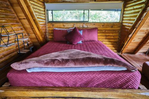 a large bed in a room in a log cabin at Skyline Ecoliving Santa Elena in Santa Elena