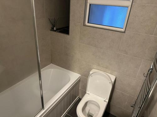 a bathroom with a toilet and a bath tub at Modern Oxford Retreat, 2Bed, 1 Bath with Parking in Oxford