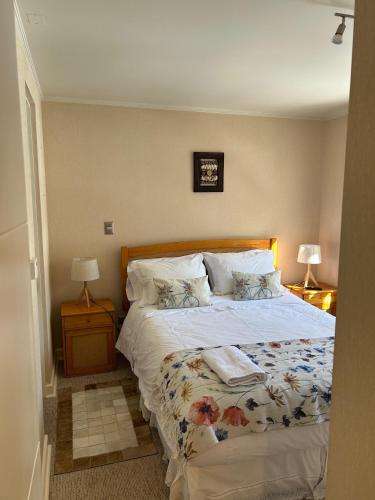 a bed in a bedroom with two lamps and a bed sidx sidx sidx at Departamentos Exclusivos Termas de Chillán in Nevados de Chillan
