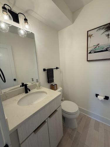 a bathroom with a sink and a toilet and a mirror at Cozy Old Town Apartment in Alexandria