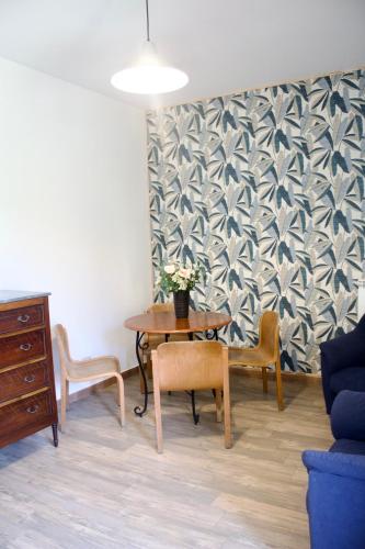a room with a table and chairs and a wall at Viola Nel Parco in SantʼAlfio