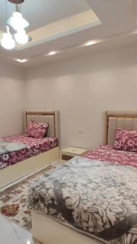 a bedroom with two beds with red and white sheets at إسراء المهندسين in Cairo