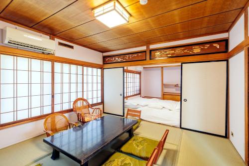 Zimmer mit einem Esstisch und einem Schlafzimmer in der Unterkunft 千本桜 in Ueda