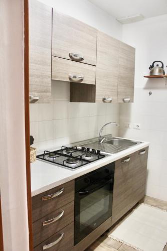 a kitchen with a stove and a sink at Viola Nel Parco in SantʼAlfio