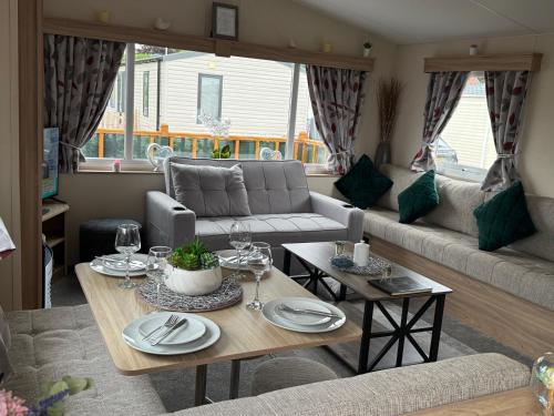 a living room with a table and a couch at Andreas Riverside Retreat at 7 Lakes Country Park in Crowle
