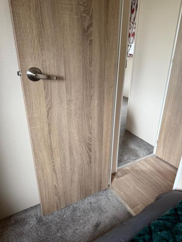 a wooden door in a room with a hallway at Andreas Riverside Retreat at 7 Lakes Country Park in Crowle