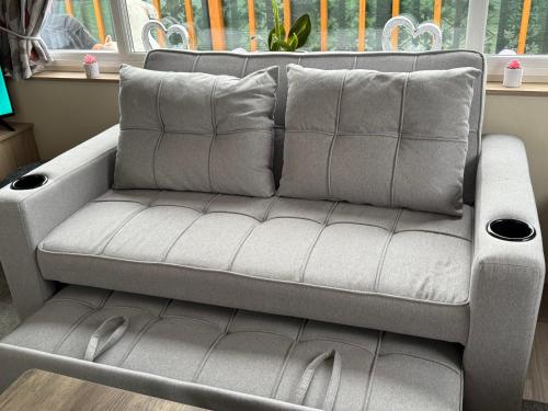 a grey couch in a room with a window at Andreas Riverside Retreat at 7 Lakes Country Park in Crowle