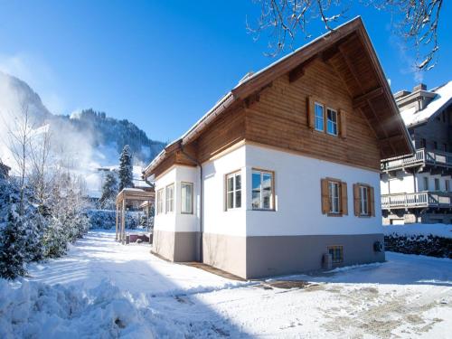 a house with a wooden roof in the snow at Stadtchalet Forsthaus in Kitzbühel