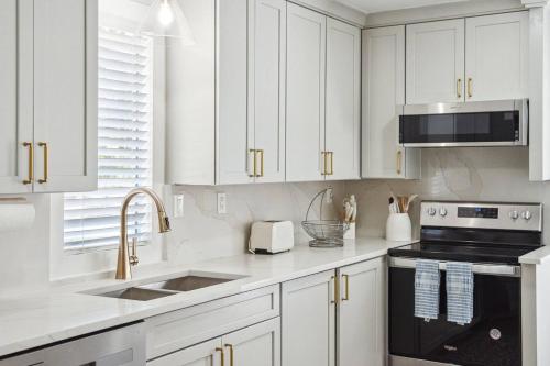 a white kitchen with white cabinets and a sink at Edisto Island Oasis in Edisto Island