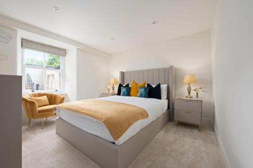 a white bedroom with a large bed and a chair at Escape to Serene Georgian Estate, near Edinburgh in Ratho