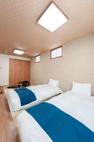two beds in a large room with a skylight at Takayama Showa no yado-A Modern Japanese-style villa with garden, excellent location in Takayama