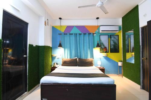 a bedroom with a bed with green and colorful walls at OYO 82026 BANGUR INN in Nager Bazaar