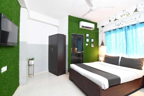 a bedroom with a bed and a green wall at OYO 82026 BANGUR INN in Nager Bazaar