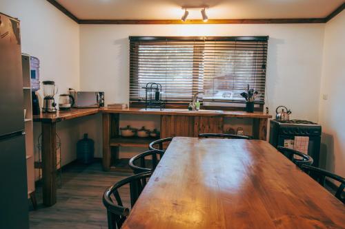a kitchen with a wooden table with chairs and a sink at Pucon Villarrica Aldea Molco in Molco