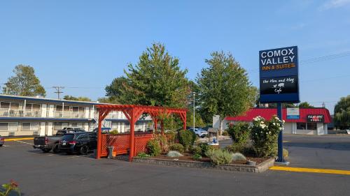 a parking lot with a sign in front of a building at Comox Valley Inn & Suites in Courtenay