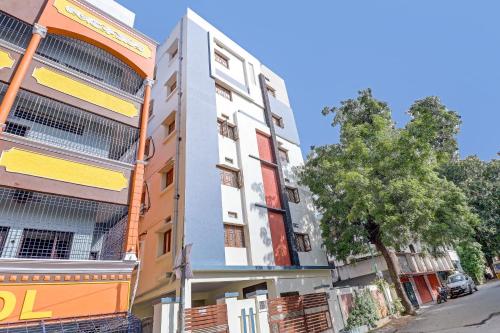 a building on the side of a street with a tree at Hotel O Abhi's R Square in Upal
