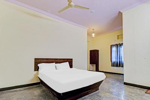 a bedroom with a white bed and a ceiling fan at Hotel O Abhi's R Square in Upal