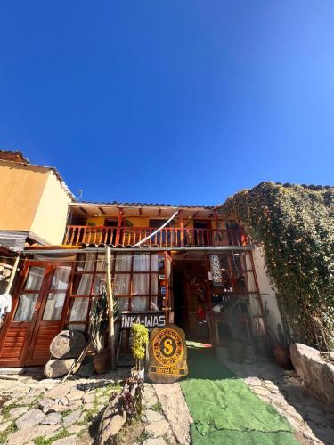 un bâtiment avec une enseigne devant lui dans l'établissement Hotel Peru Ollantay, à Ollantaytambo