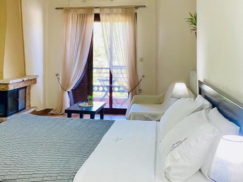 a bedroom with a large bed and a fireplace at Gea Kaimaktsalan Hotel & Spa in Kato Loutraki