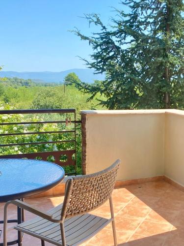 a table and chair on a balcony with a view at Gea Kaimaktsalan Hotel & Spa in Kato Loutraki