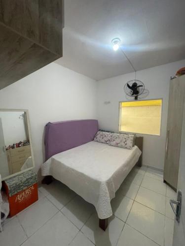 a small bedroom with a bed and a window at Casa com piscina in Ilhabela