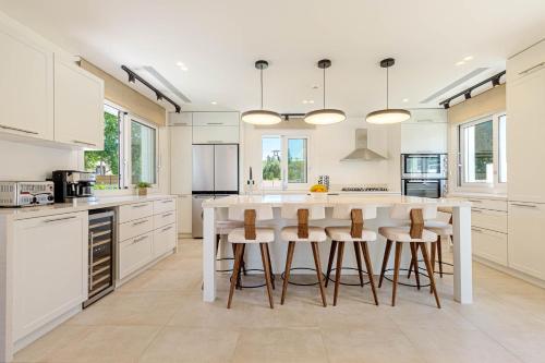 a kitchen with a white island with bar stools at Luxury Villa Rika Corfu- 5 bedrooms with Pool in Gouvia