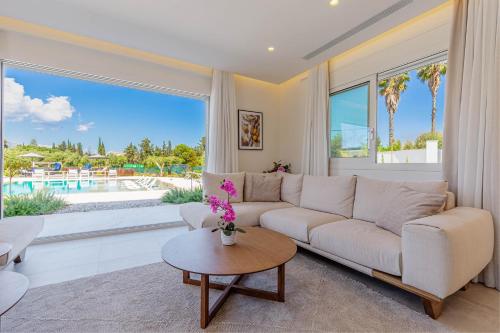 a living room with a couch and a large window at Luxury Villa Rika Corfu- 5 bedrooms with Pool in Gouvia