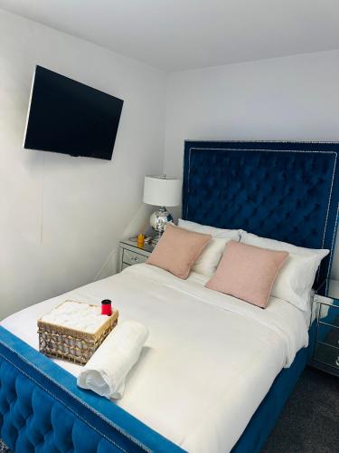 een bed met een blauw hoofdeinde met een mand erop bij Hotel Feel, Home Comfort in Manchester