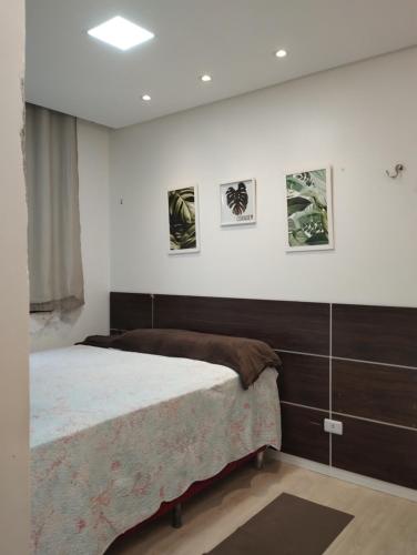 a bedroom with a bed and some pictures on the wall at APARTAMENTO COP30 - Natureza e bem estar juntos in Ananindeua