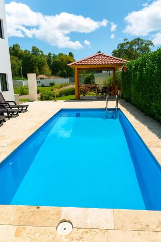 a blue swimming pool with a gazebo at Modern 3 Bedroom Penthouse Apartment with Free Parking in San Felipe de Puerto Plata