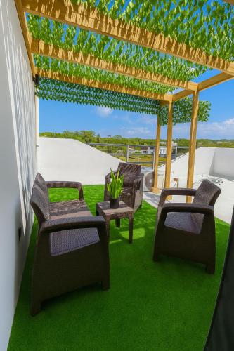 a patio with chairs and a pergola at Modern 3 Bedroom Penthouse Apartment with Free Parking in San Felipe de Puerto Plata